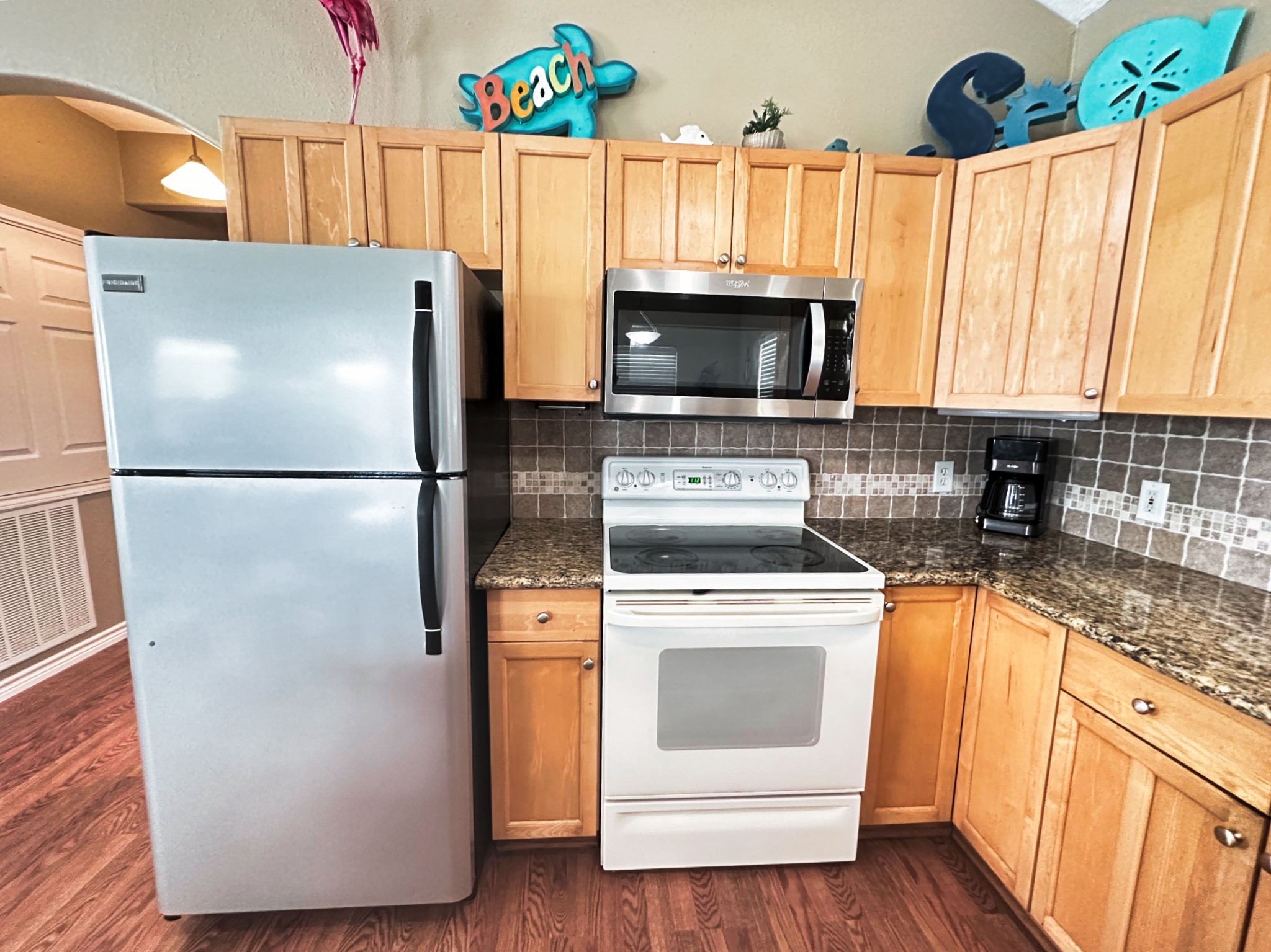 1867 County Road 291 Sargent, TX 77414 - Photo 17 of 38 a kitchen with a refrigerator a stove a microwave and wooden floor