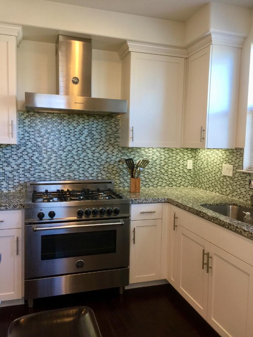 458 Landeros Drive San Mateo, CA 94403 - Photo 10 of 42 a kitchen with a stove and white cabinets