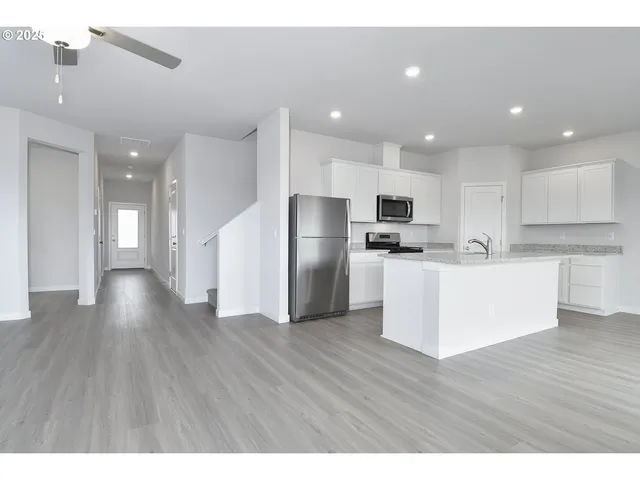 a view of kitchen with refrigerator microwave and wooden floor