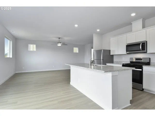 a kitchen with kitchen island a sink stainless steel appliances and cabinets