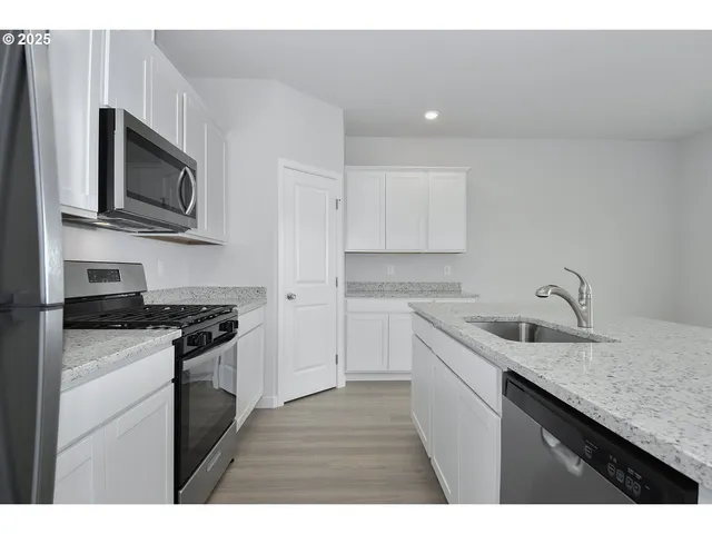 a kitchen with stainless steel appliances granite countertop a sink stove and microwave
