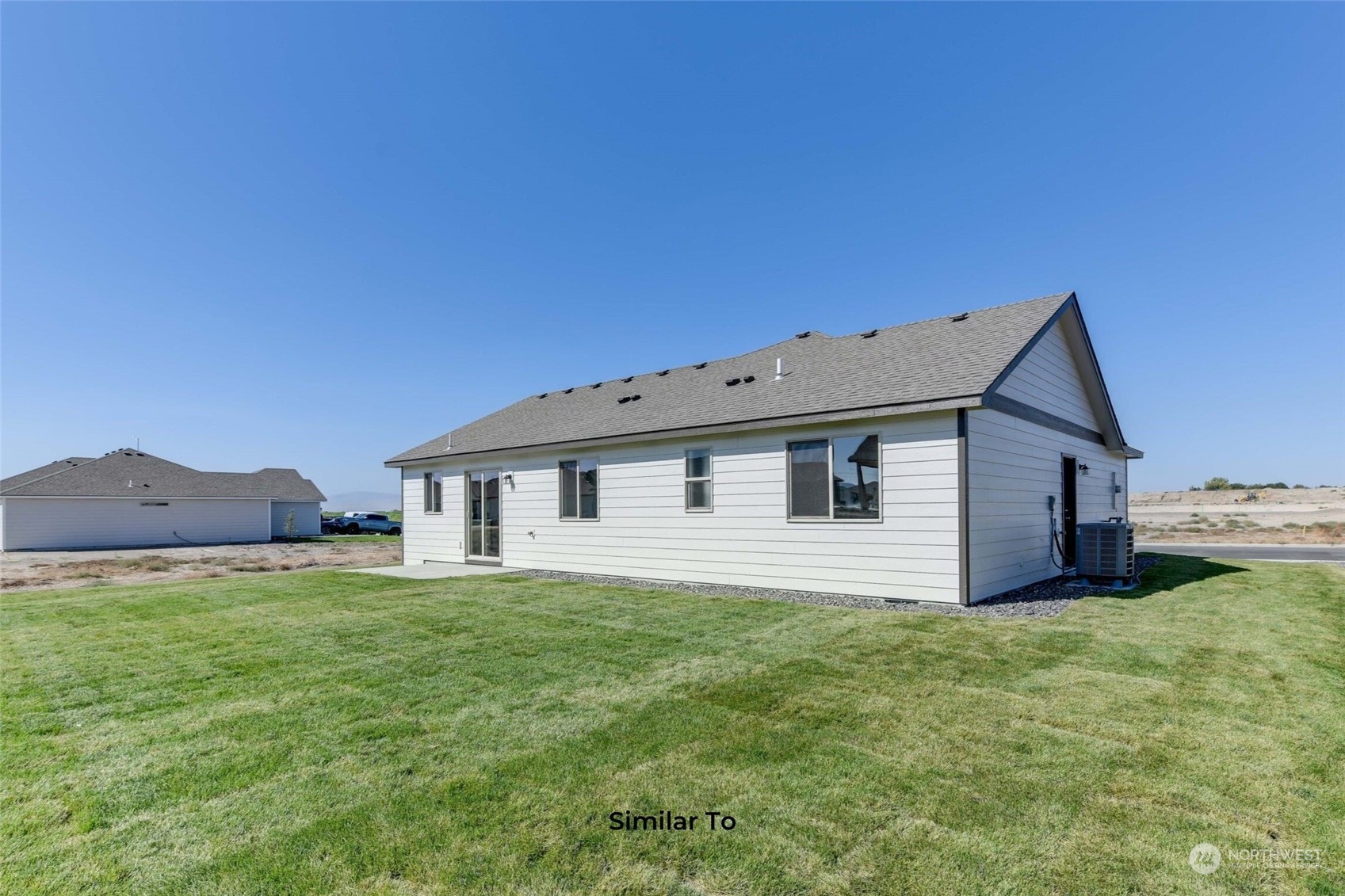 209 North Sandy Loop Moses Lake, WA 98837 - Photo 17 of 19 a house that is sitting in the grass with large trees