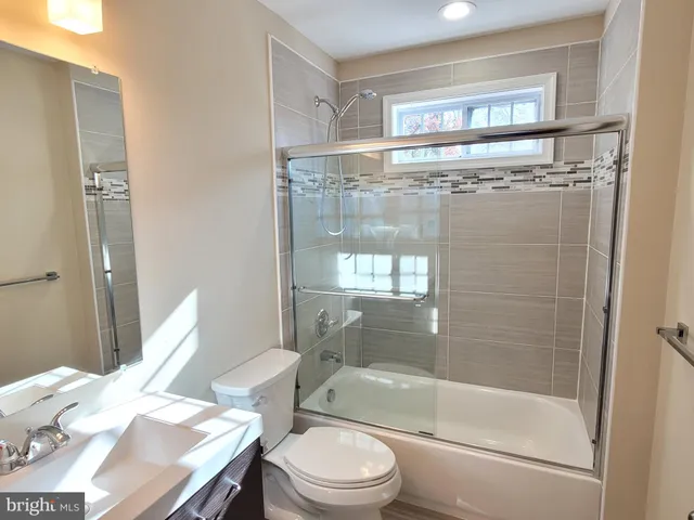 a bathroom with a tub a mirror and a shower