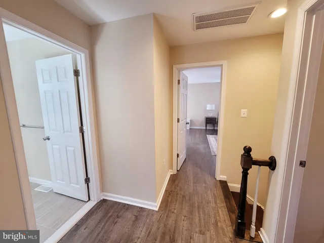 a view of a hallway with wooden floor and staircase