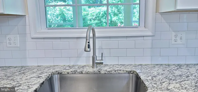 a bathroom with a granite countertop sink and window