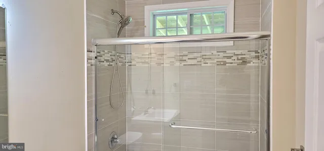 a bathroom with a granite countertop bathtub shower sink vanity and toilet