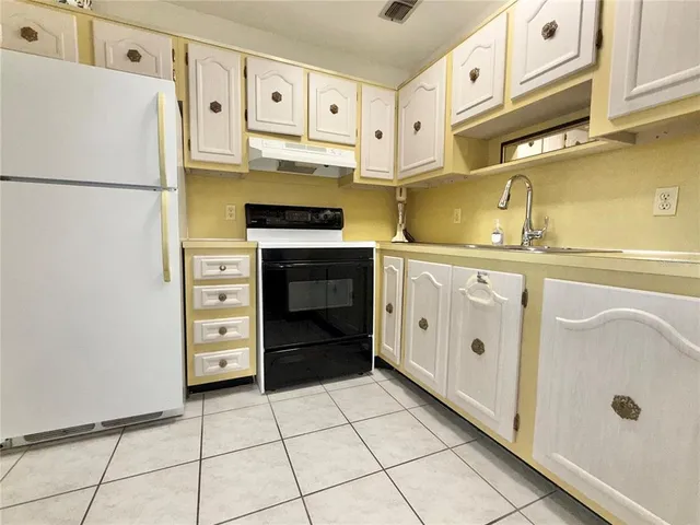 a kitchen with stainless steel appliances a stove a refrigerator and cabinets