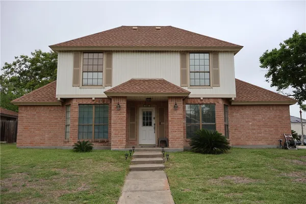a front view of a house with a garden