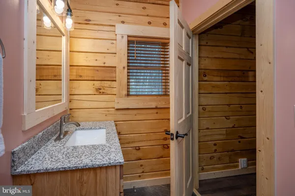 a bathroom with a granite countertop toilet sink and mirror
