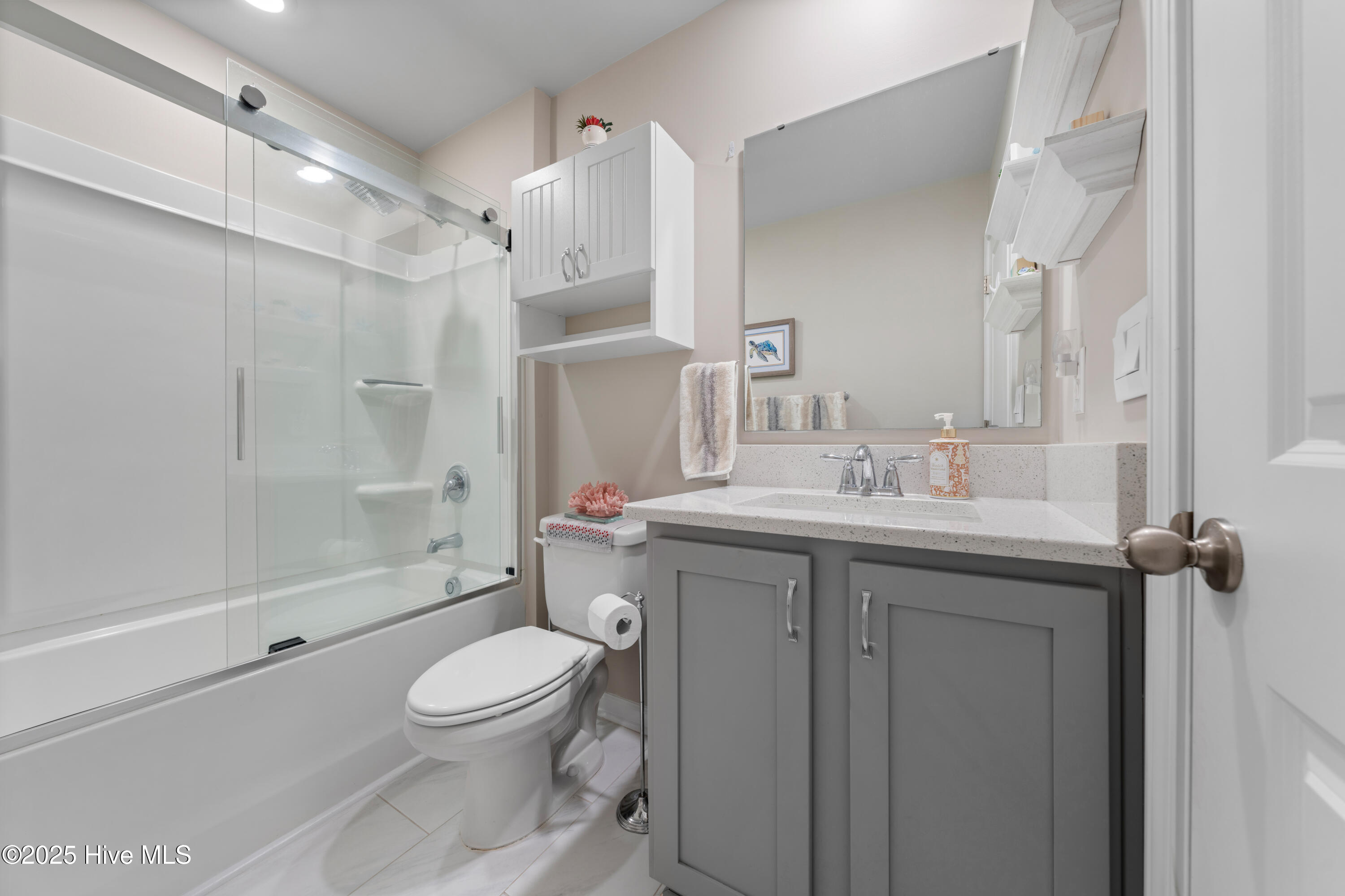 776 Buckeye Road Northeast Leland, NC 28451 - Photo 38 of 42 New Quartz Countertop, Cabinetry above Commode and Shower Door upgraded to a Kohler by-pass slider