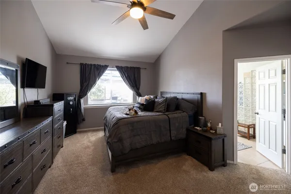 a spacious bedroom with a bed and a flat screen tv