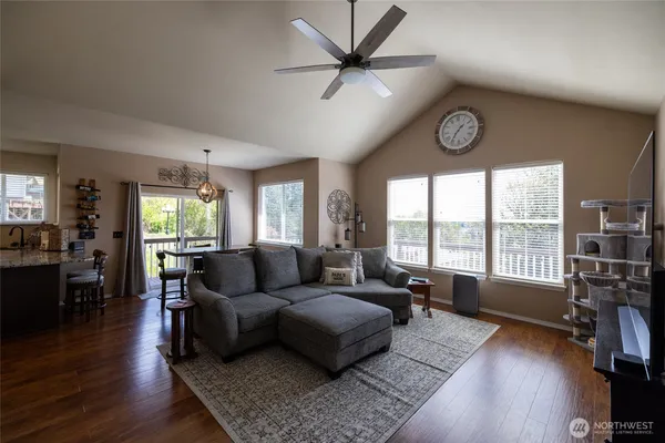 a living room with furniture large window and wooden floor