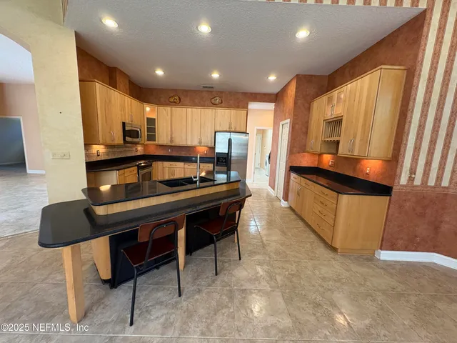 a kitchen with a table chairs refrigerator and microwave