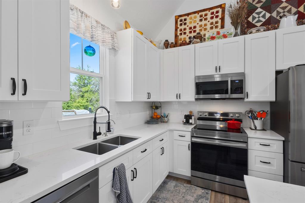 116 Lindsey Lane Runaway Bay, TX 76426 - Photo 16 of 35 a kitchen with stainless steel appliances a white cabinets and a stove top oven