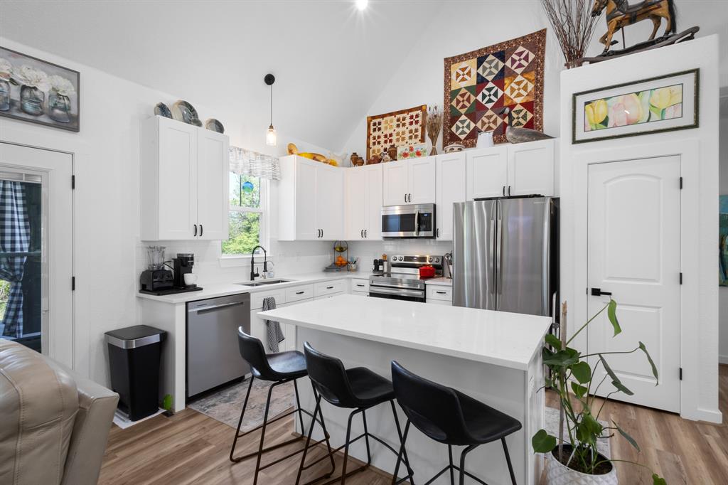 116 Lindsey Lane Runaway Bay, TX 76426 - Photo 17 of 35 a kitchen with stainless steel appliances a refrigerator and a stove with wooden floor