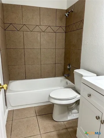 a white toilet and tub sitting next to a bathroom sink