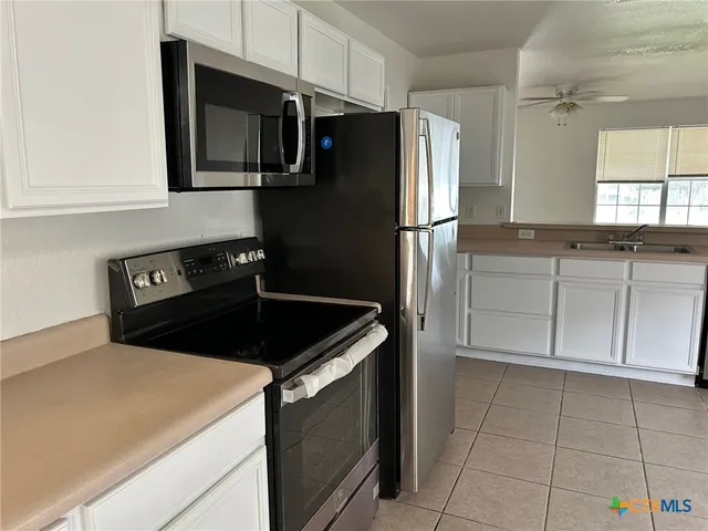a kitchen with a refrigerator stove and cabinets