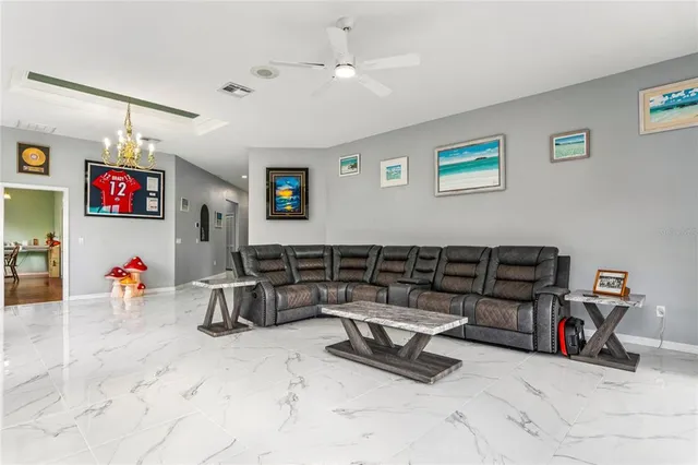 a dining room with furniture a chandelier and wooden floor