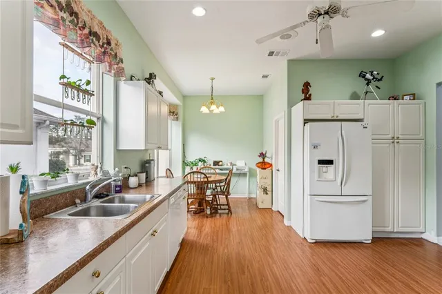 a kitchen with stainless steel appliances kitchen island a table chairs in it and wooden floor