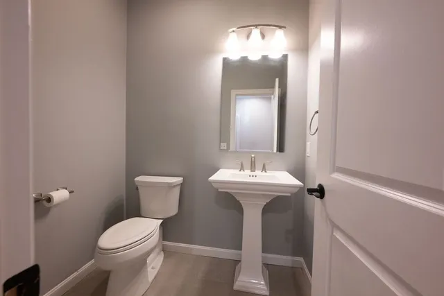 a bathroom with a toilet a sink and mirror