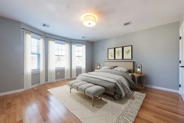 a bedroom with a bed and painting on the wall