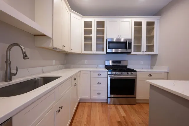 a kitchen with stainless steel appliances granite countertop a stove and a sink