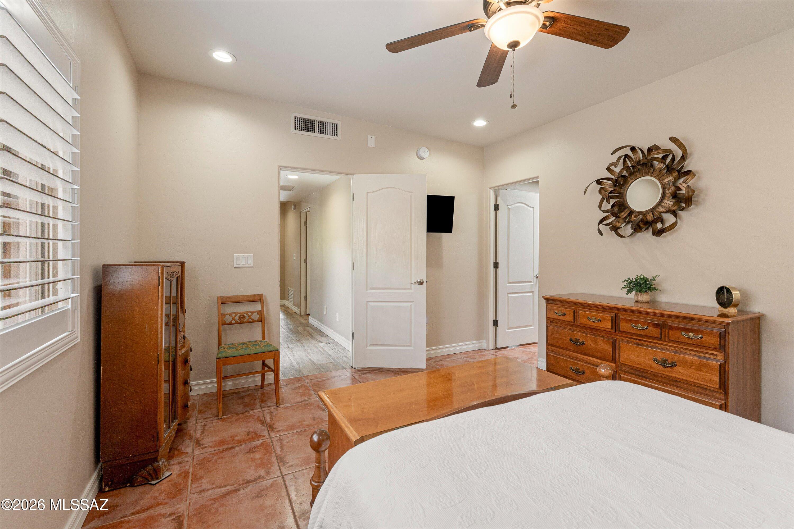4760 East Wagon Train Road Tucson, AZ 85739 - Photo 31 of 38 a bedroom with a bed and a chandelier