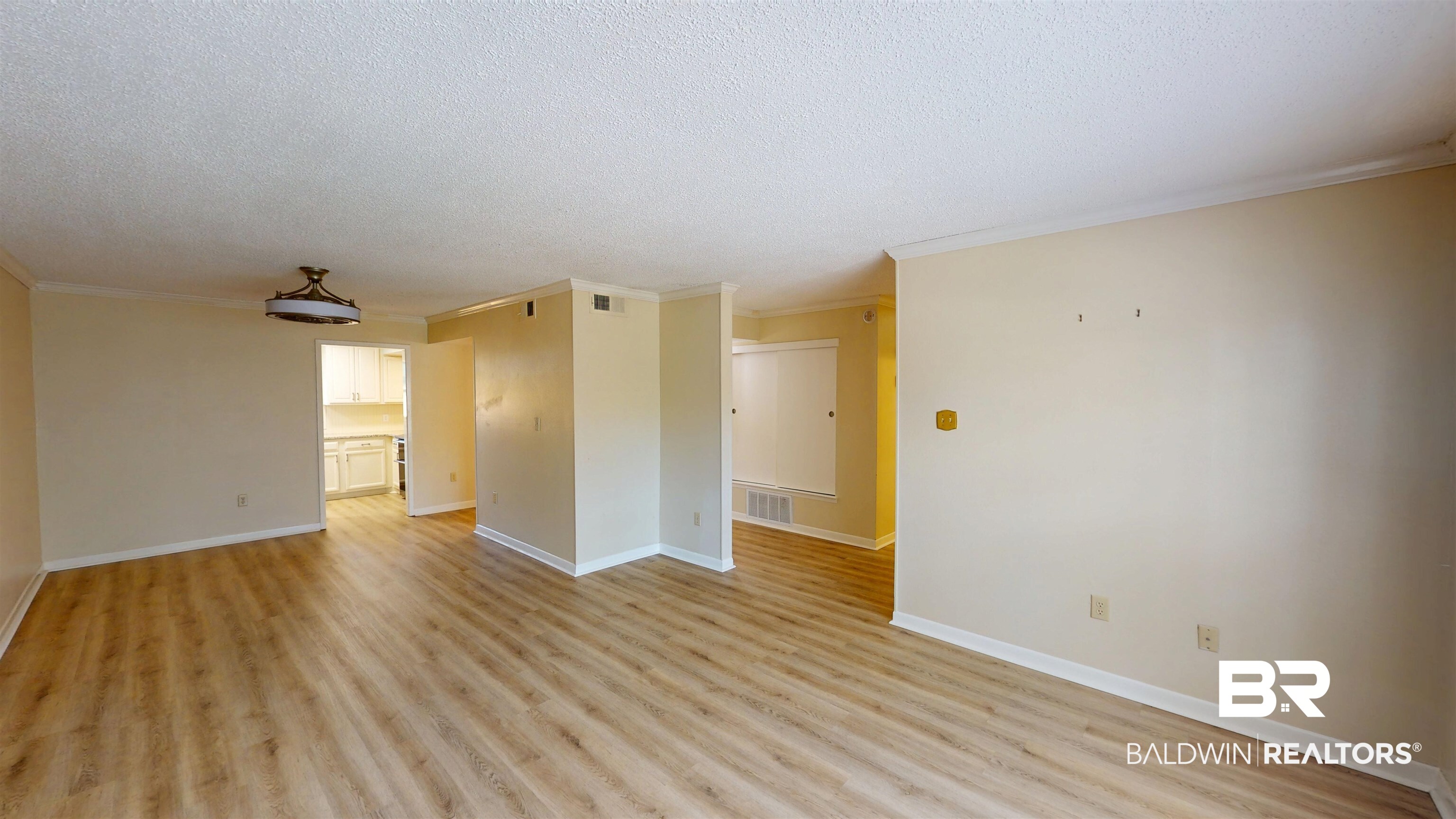 2901 Grant Street, Unit 902 Mobile, AL 36606 - Photo 3 of 35 Unfurnished room with light wood-style flooring, ornamental molding, and a textured ceiling