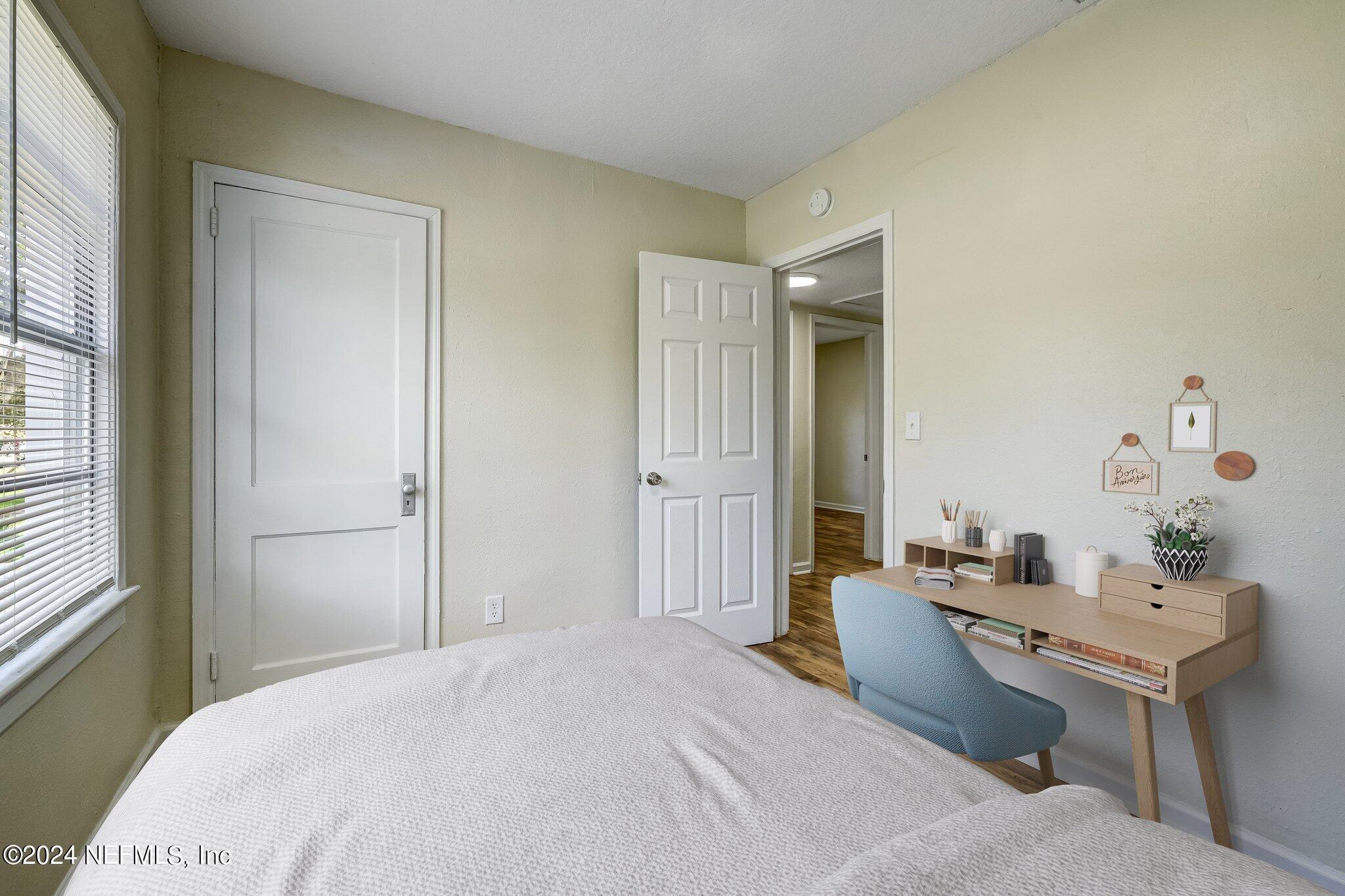 4917 Dundee Road Jacksonville, FL 32210 - Photo 14 of 26 a bedroom with a bed a mirror and a sink