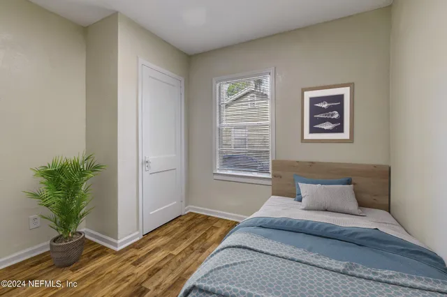 a bedroom with a bed and a potted plant