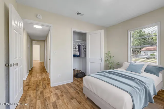 a bedroom with a bed and a large window