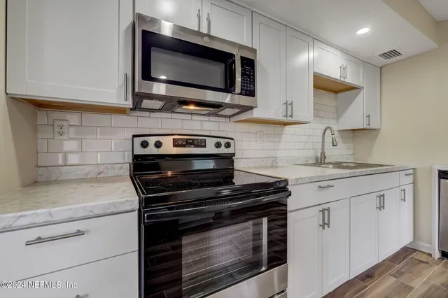 a kitchen with stainless steel appliances granite countertop a stove microwave and cabinets