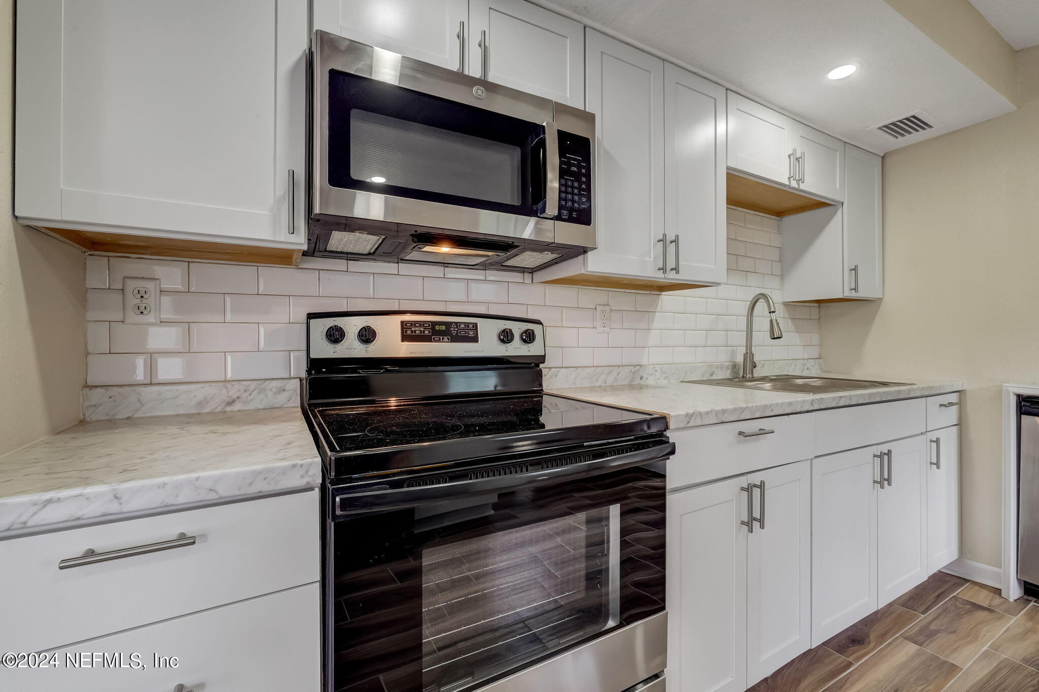4917 Dundee Road Jacksonville, FL 32210 - Photo 6 of 26 a kitchen with stainless steel appliances granite countertop a stove microwave and cabinets