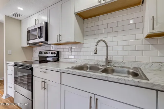 a kitchen with stainless steel appliances granite countertop a sink and a stove