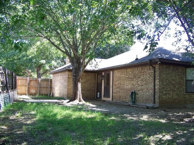 a view of a house with a yard and tree