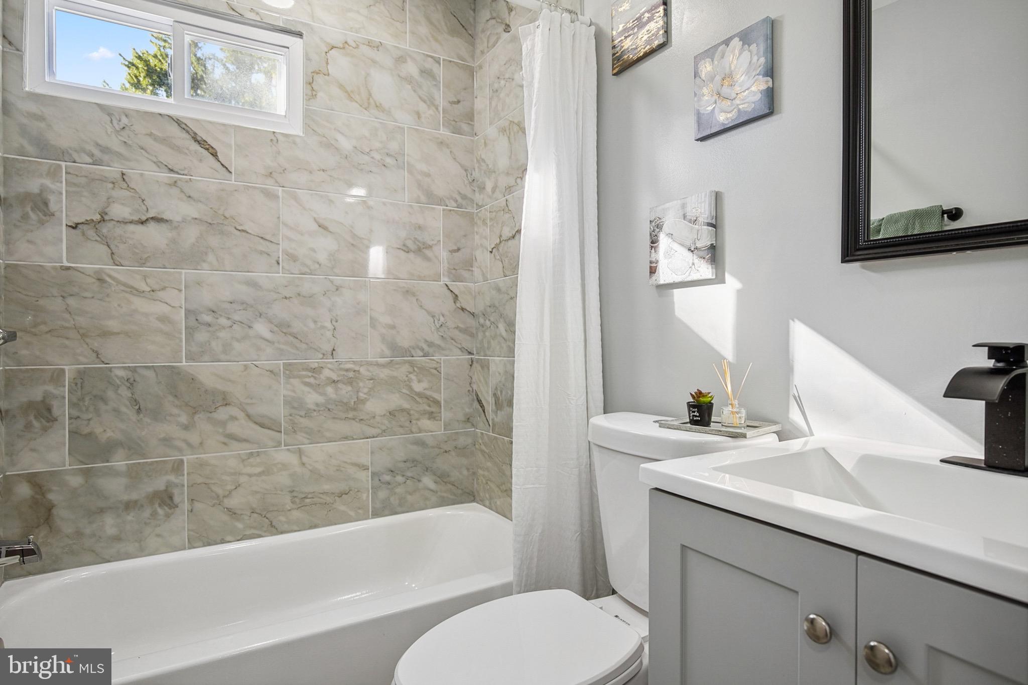 2501 North Point Road Dundalk, MD 21222 - Photo 13 of 28 a bathroom with a sink a toilet and bathtub