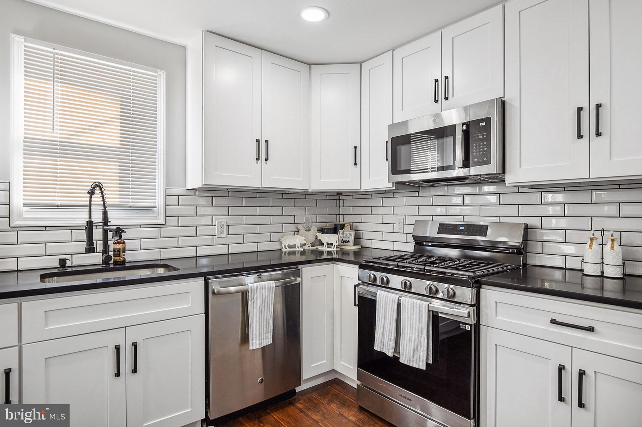 2501 North Point Road Dundalk, MD 21222 - Photo 8 of 28 a kitchen with white cabinets and appliances