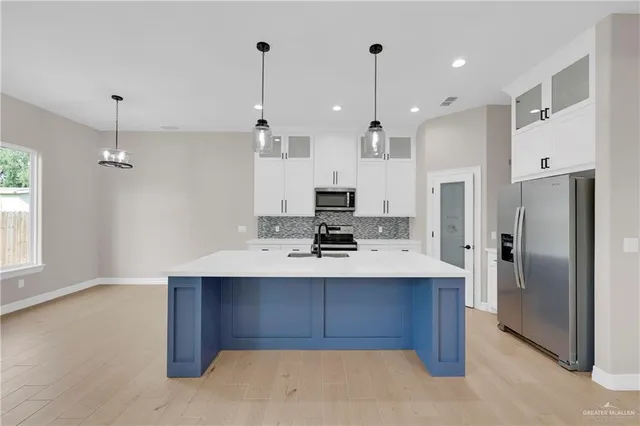a kitchen with kitchen island a sink stainless steel appliances and window