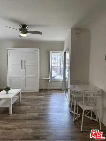 a view of an empty room with a window and wooden floor