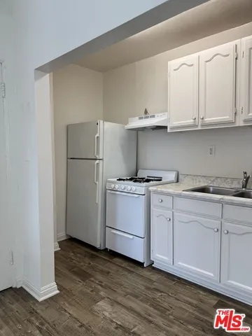 a kitchen with white cabinets and white appliances
