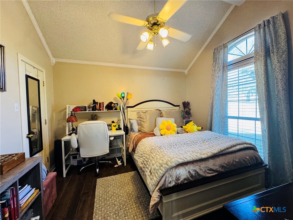 115 Oak Ridge Road Gatesville, TX 76528 - Photo 27 of 37 a bedroom with a bed a dresser and book shelfs