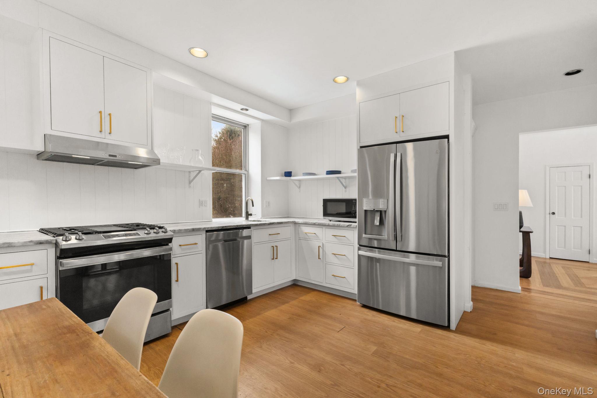 a kitchen with stainless steel appliances granite countertop a refrigerator stove and wooden floor