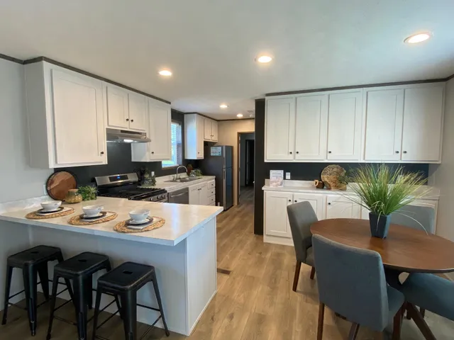 a kitchen with a dining table chairs and refrigerator