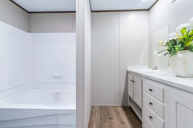 a bathroom with a tub sink and mirror