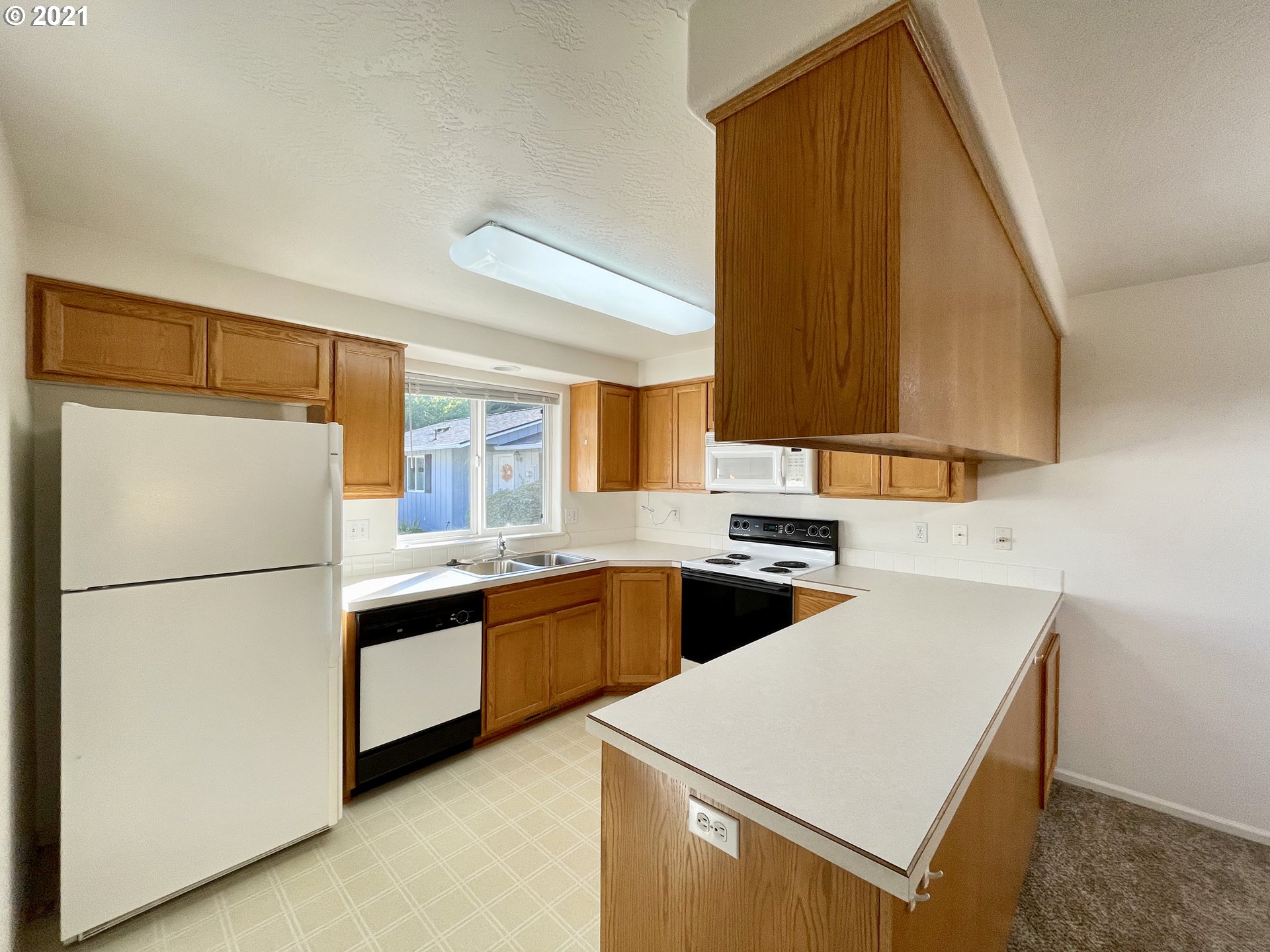 994 West L Street Springfield, OR 97477 - Photo 6 of 26 a kitchen with a sink a refrigerator and cabinets