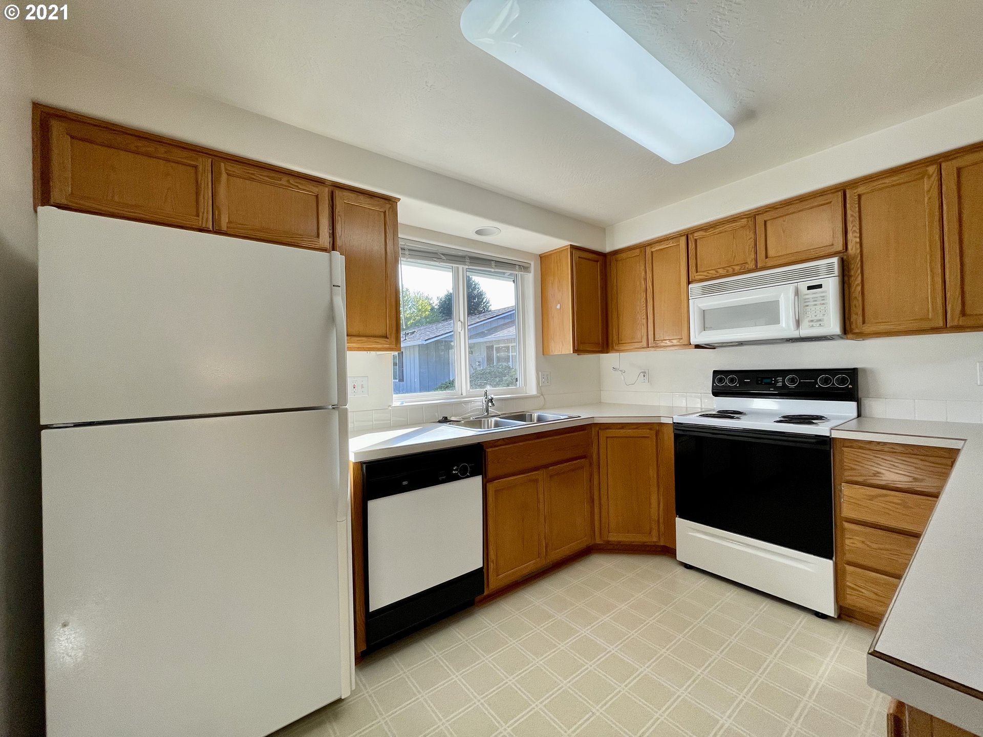 994 West L Street Springfield, OR 97477 - Photo 7 of 26 a kitchen with stainless steel appliances granite countertop a refrigerator a stove a sink and a microwave