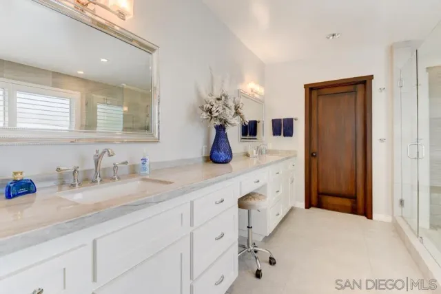 a bathroom with a sink double vanity granite and a mirror