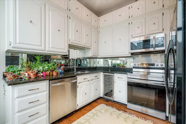 a kitchen with stainless steel appliances granite countertop a stove and cabinets