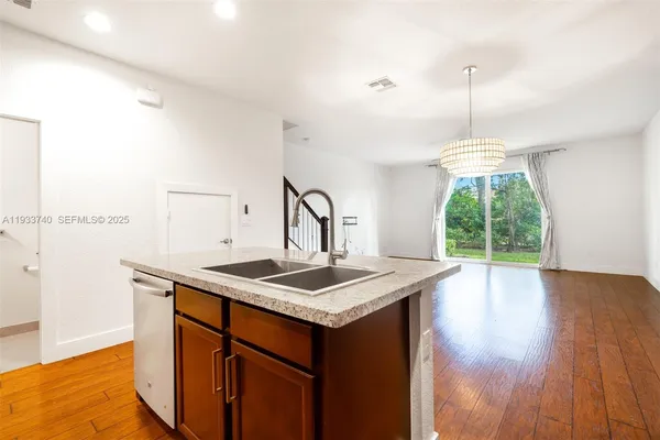 a kitchen with a sink a window and wooden floor