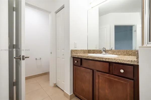 a bathroom with a granite countertop sink a mirror and a shower